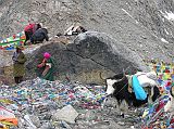 Tibet Kailash 09 Kora 09 Pilgrims on Dolma Rock on Dolma La The actual crossing represents the transition from this life to a new one. Here the pilgrim is reborn and all sins forgiven because of the compassion of Dlma, the Goddess of Mercy. At the pass, pilgrims shout aloud verbal offerings and perform a circumambulation of Dlmas Rock, pasting money onto the rock with butter, stooping to pass under the lines of prayer flags